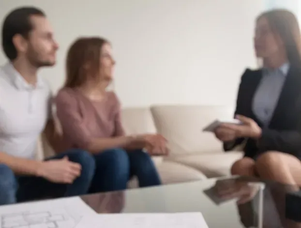 A Couple Are Talking With A Lawyer on a Couch — McVittie Legal In Ballina, NSW