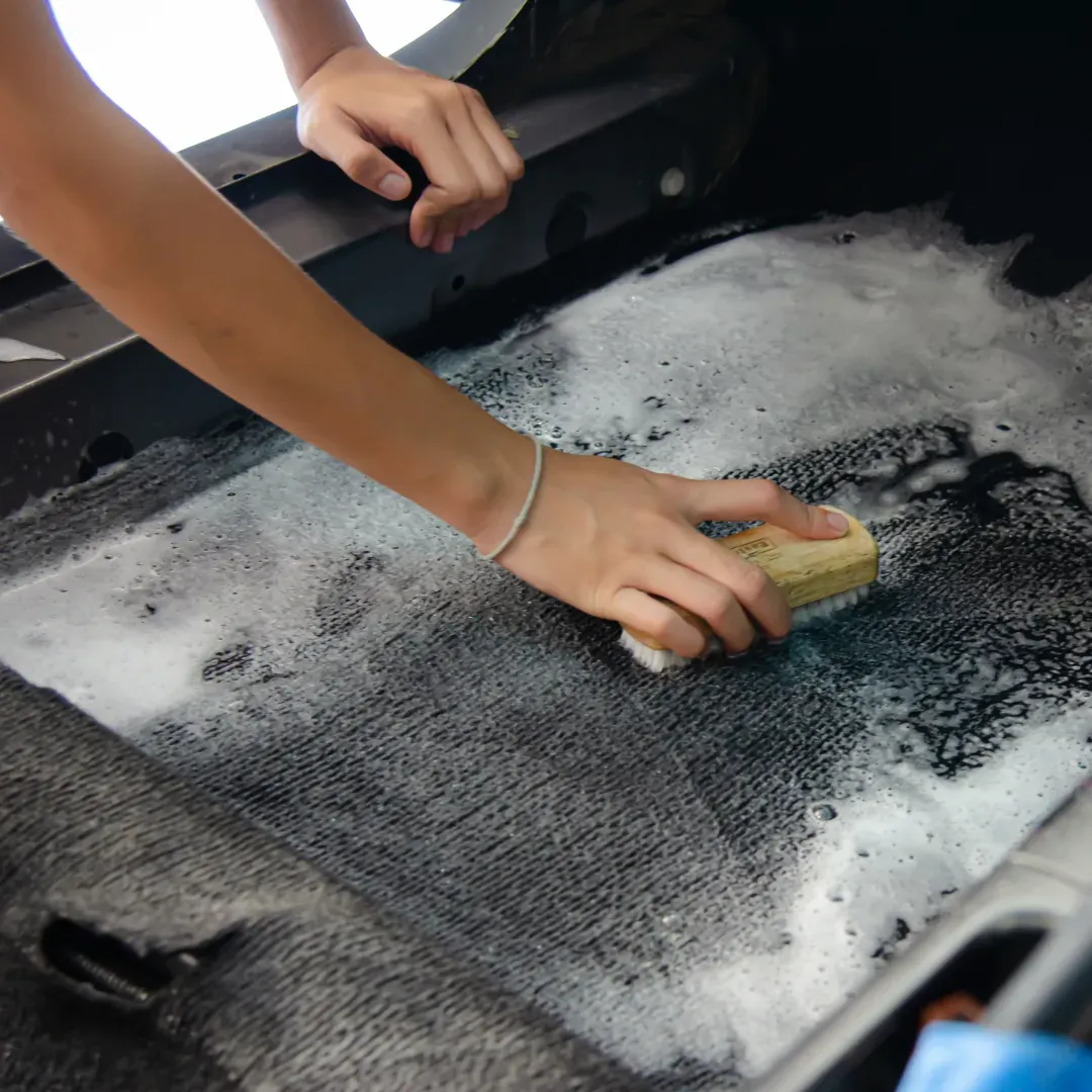 Blas Carpet professional agitating stains on car carpet using the upholstery shampooing method in Atlanta, Georgia.