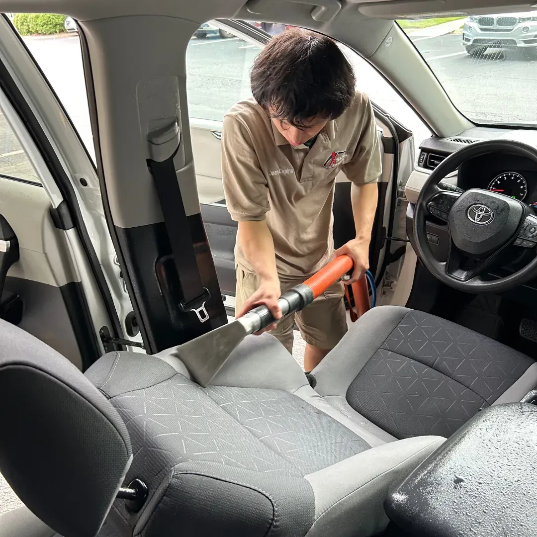 Blas Carpet technician removing stains on car seats using the upholstery steam cleaning method.
