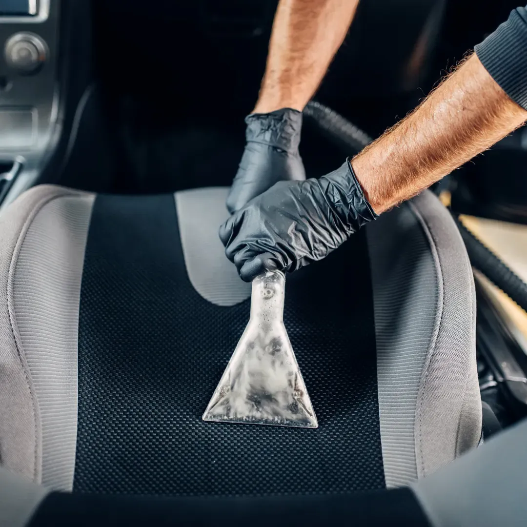 Blas Carpet professional removing stains on car seats using the upholstery steam cleaning method in Atlanta, Georgia.