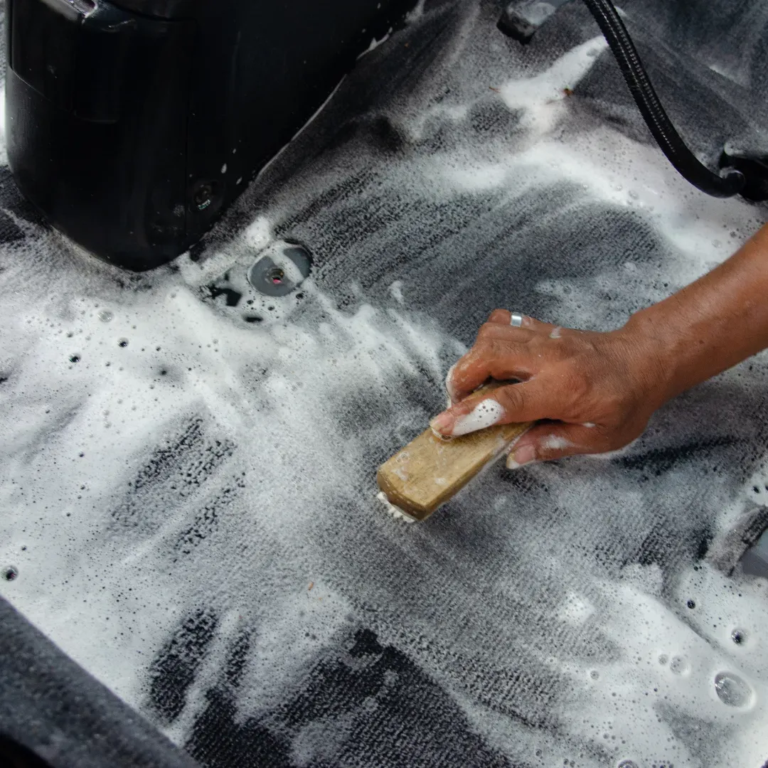 Blas Carpet expert scrubbing stains off carpet using the car shampooing method in Denver, Colorado.