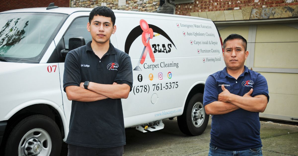 Two Blas Carpet team members posing in from of work van.
