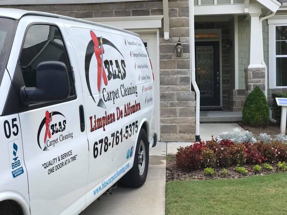 Blas Carpet van is parked in front of the job site.
