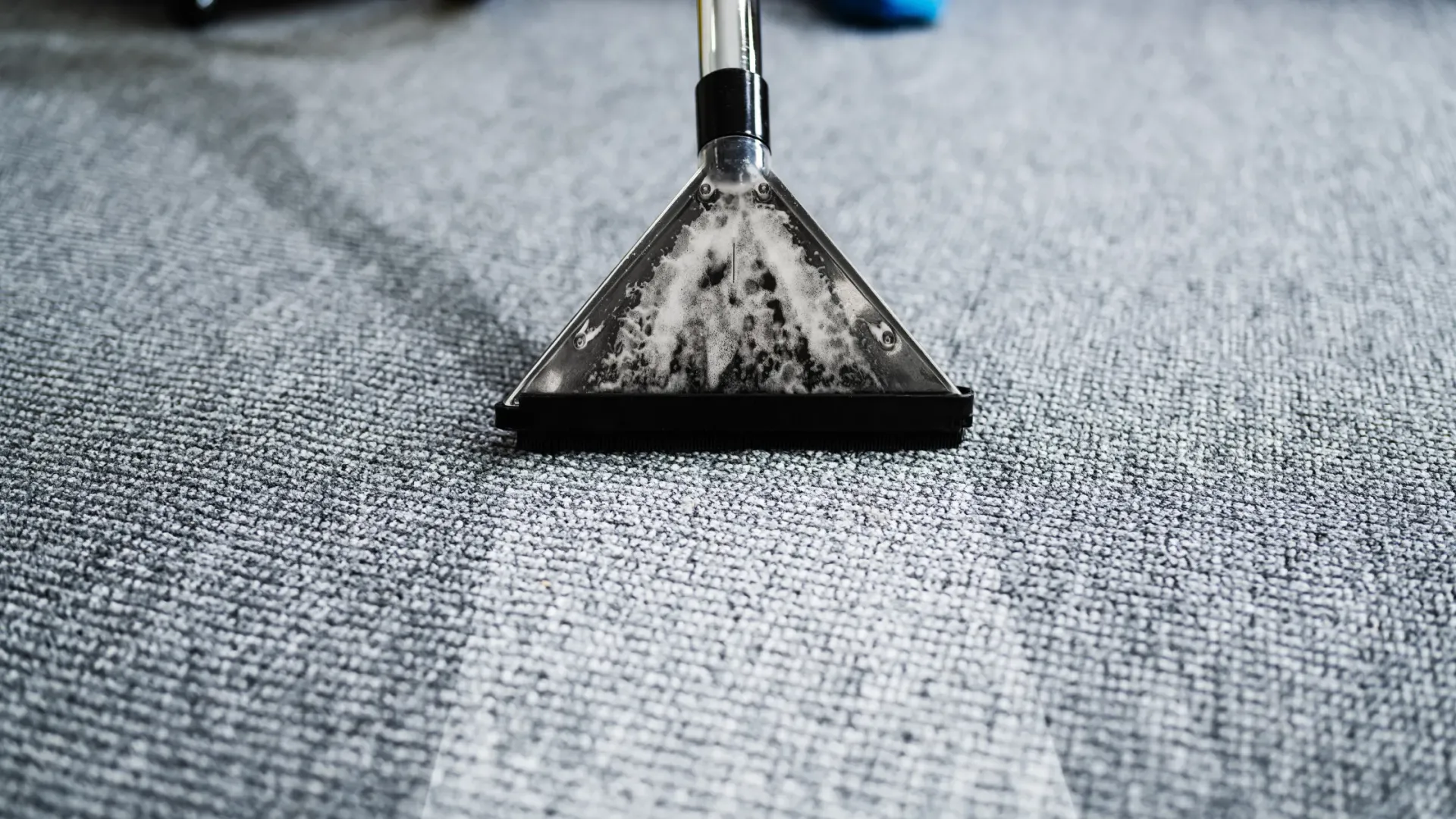 Dirty office carpet being professionally carpet cleaned.