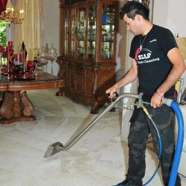 Professional carpet cleaning technician steam cleaning living room carpet in Atlanta, Georgia home.