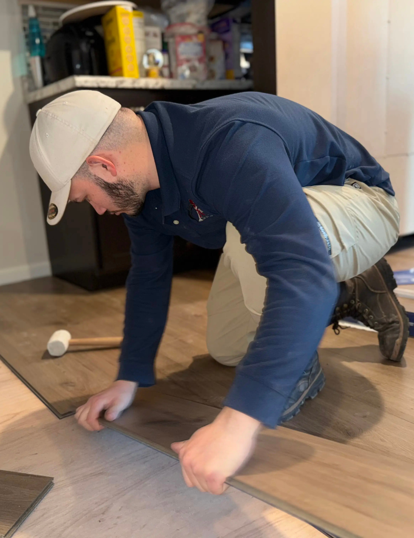 Luxury vinyl plank flooring installation specialist working.