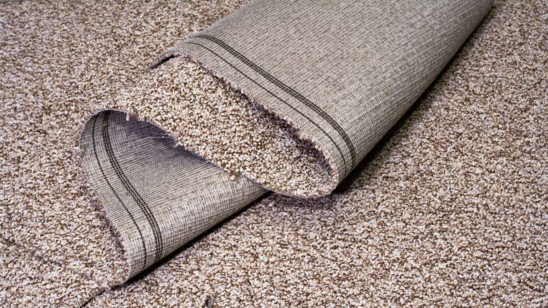 Loose carpet laying in a home bedroom before getting installed.