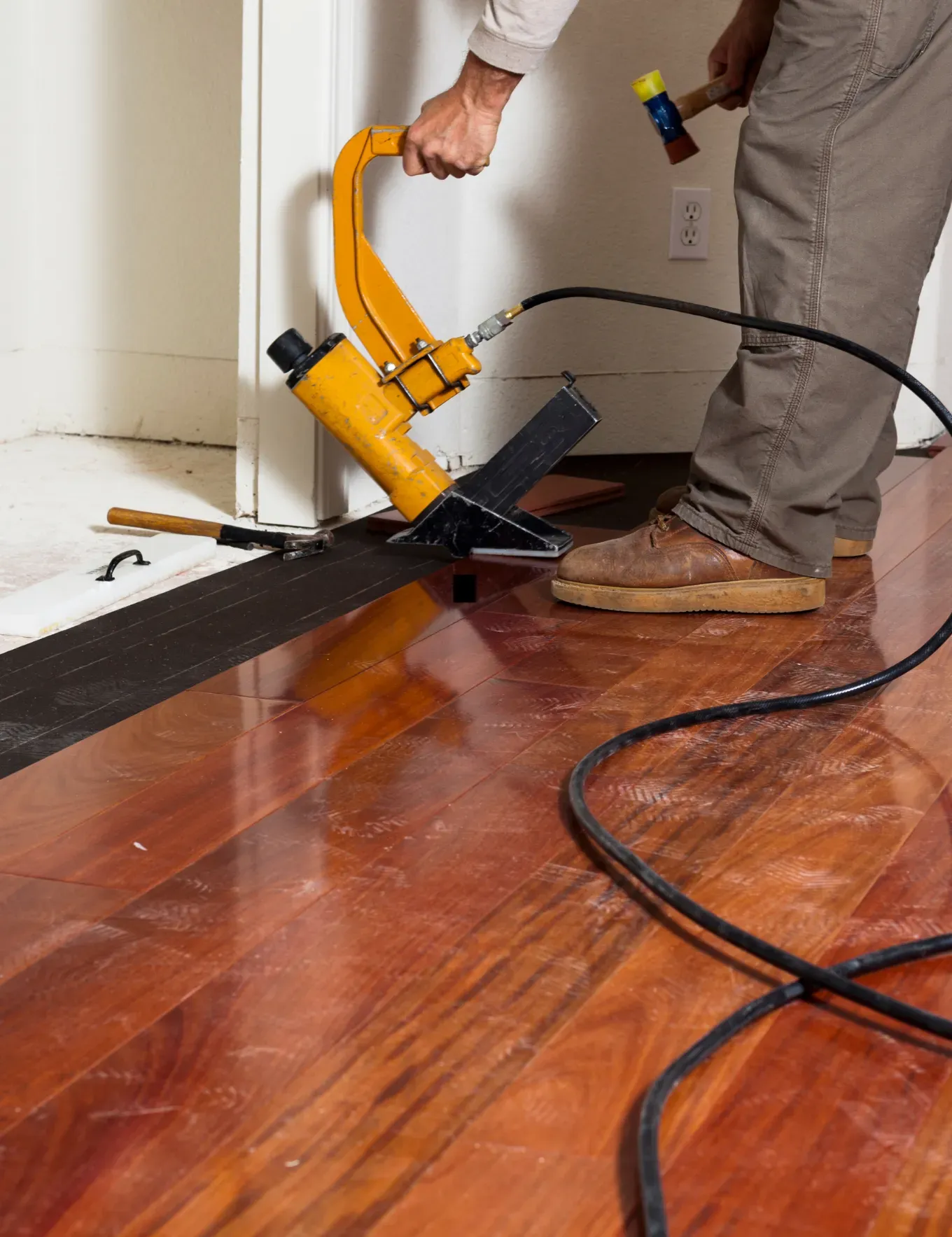 Hardwood flooring installation specialist laying down floors.