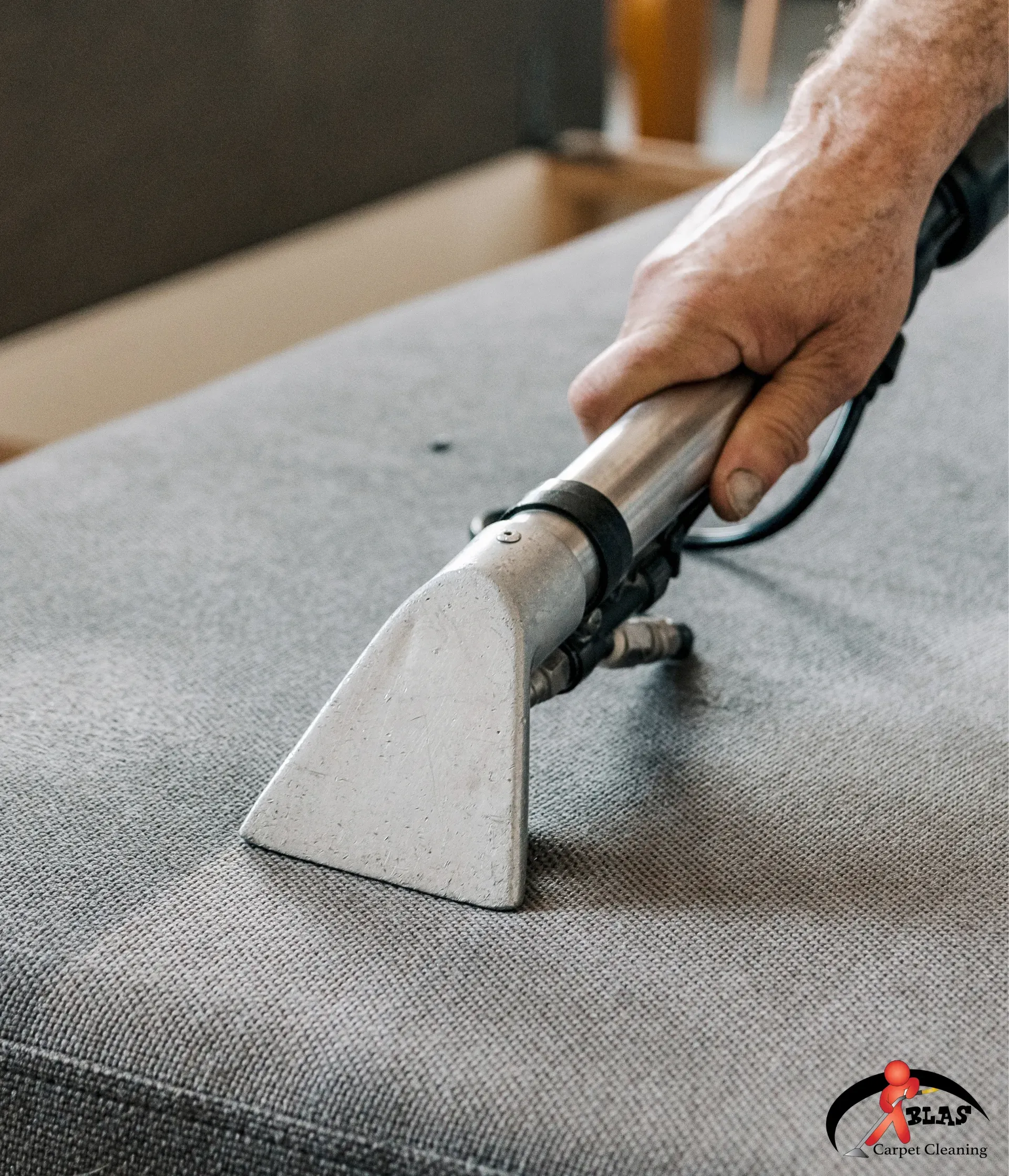 Professional upholstery cleaning specialist removing stains from sofa in Atlanta, Georgia home.