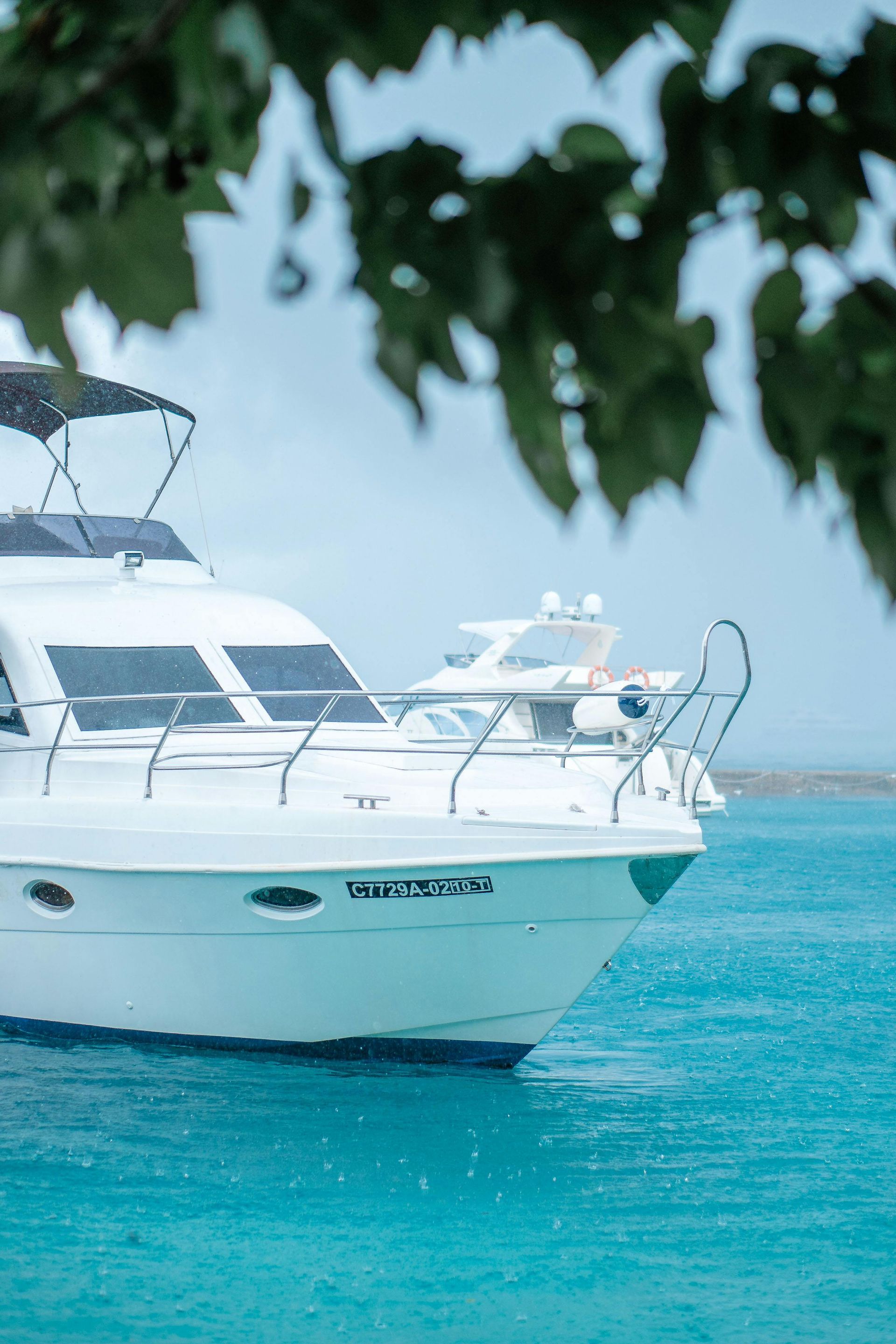 A white yacht is floating on top of a blue ocean.