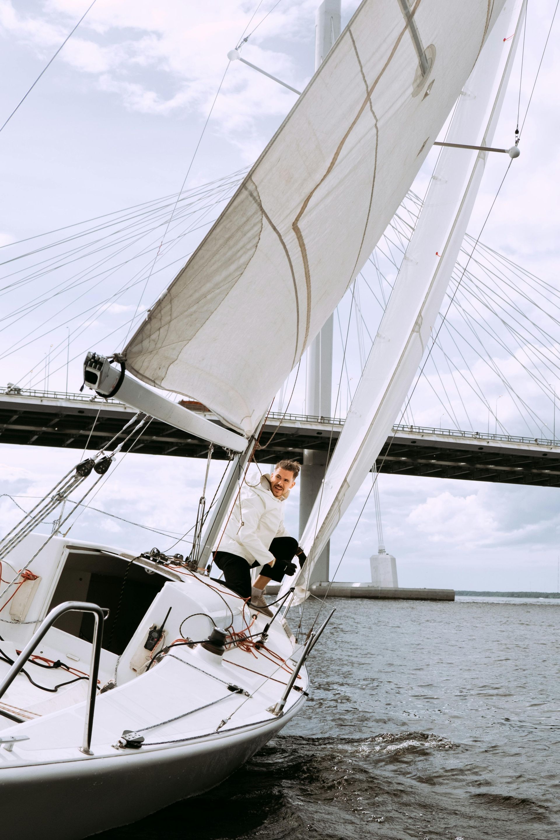 A man and a dog are sitting on a sailboat in the water.