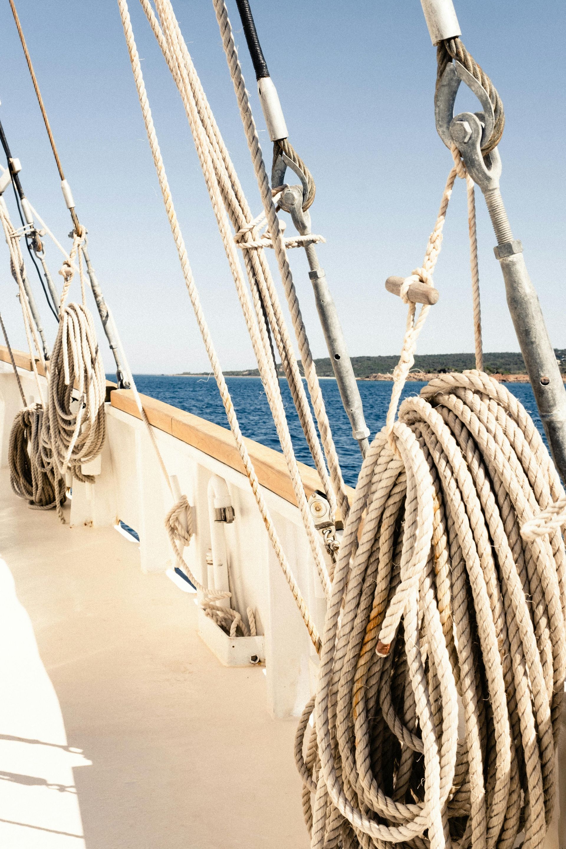 A rope is hanging from the side of a boat in the ocean.