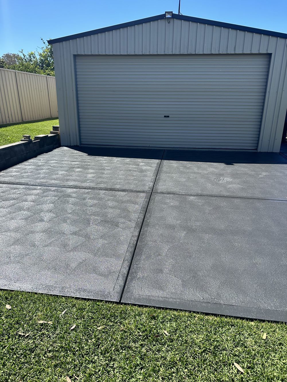 A garage with a concrete driveway in front of it  — LMS Painting & Maintenance Pty Ltd In North Lambton, NSW