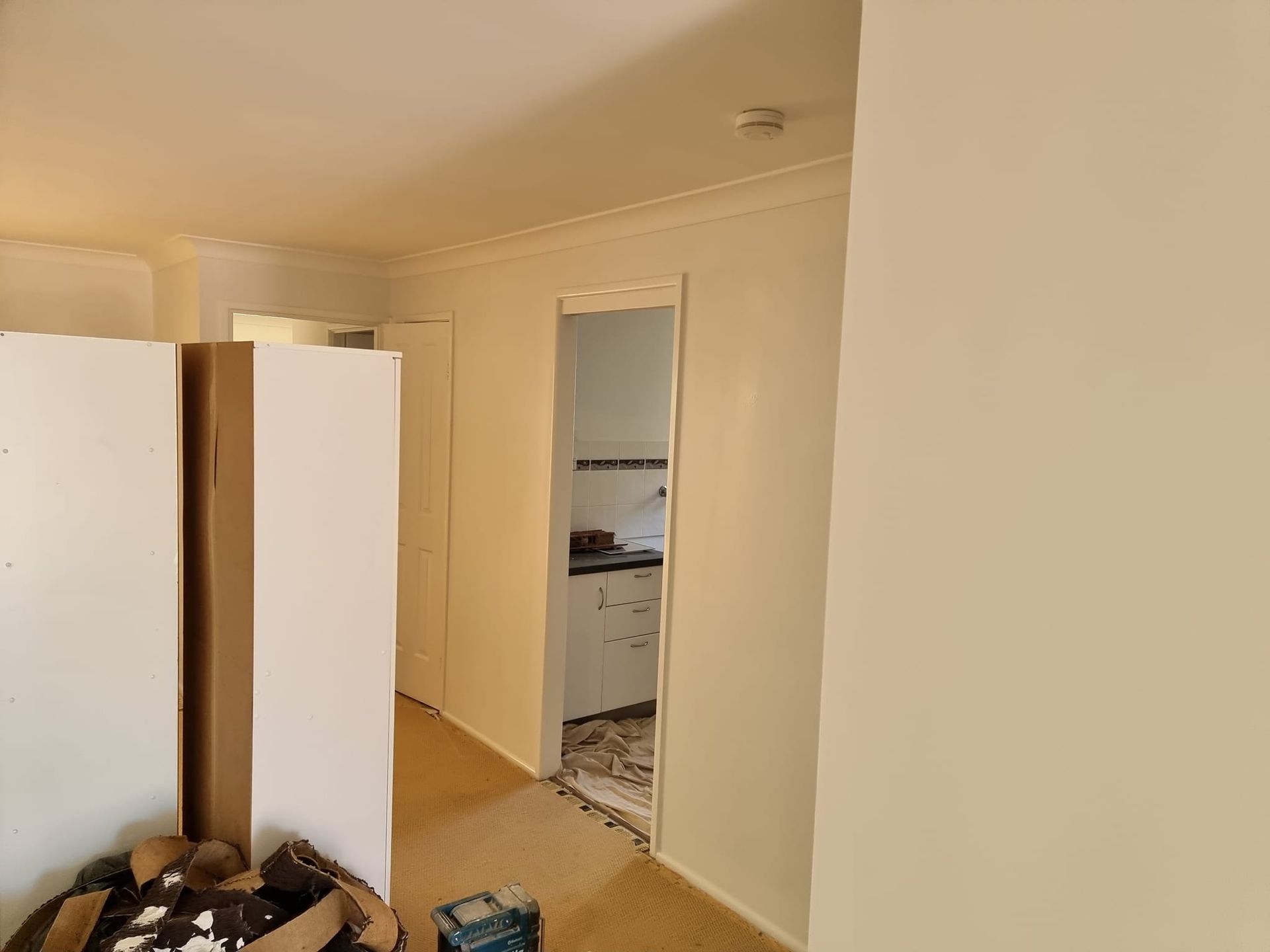 A Room With White Walls And A Doorway Leading To A Kitchen — LMS Painting & Maintenance Pty Ltd In Lake Macquarie, NSW