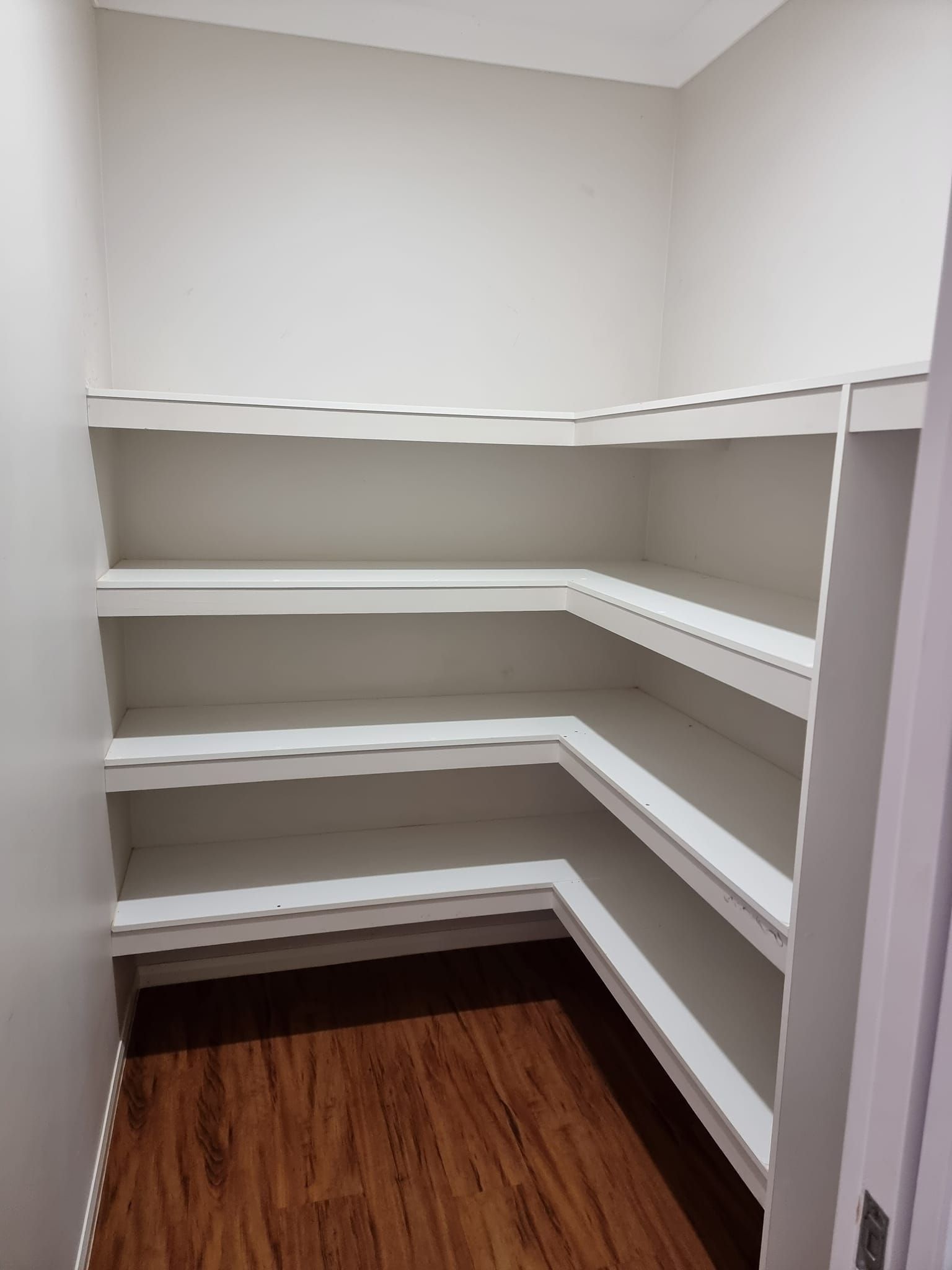 An Empty Pantry With Wooden Floors And White Shelves — LMS Painting & Maintenance Pty Ltd In Medowie, NSW
