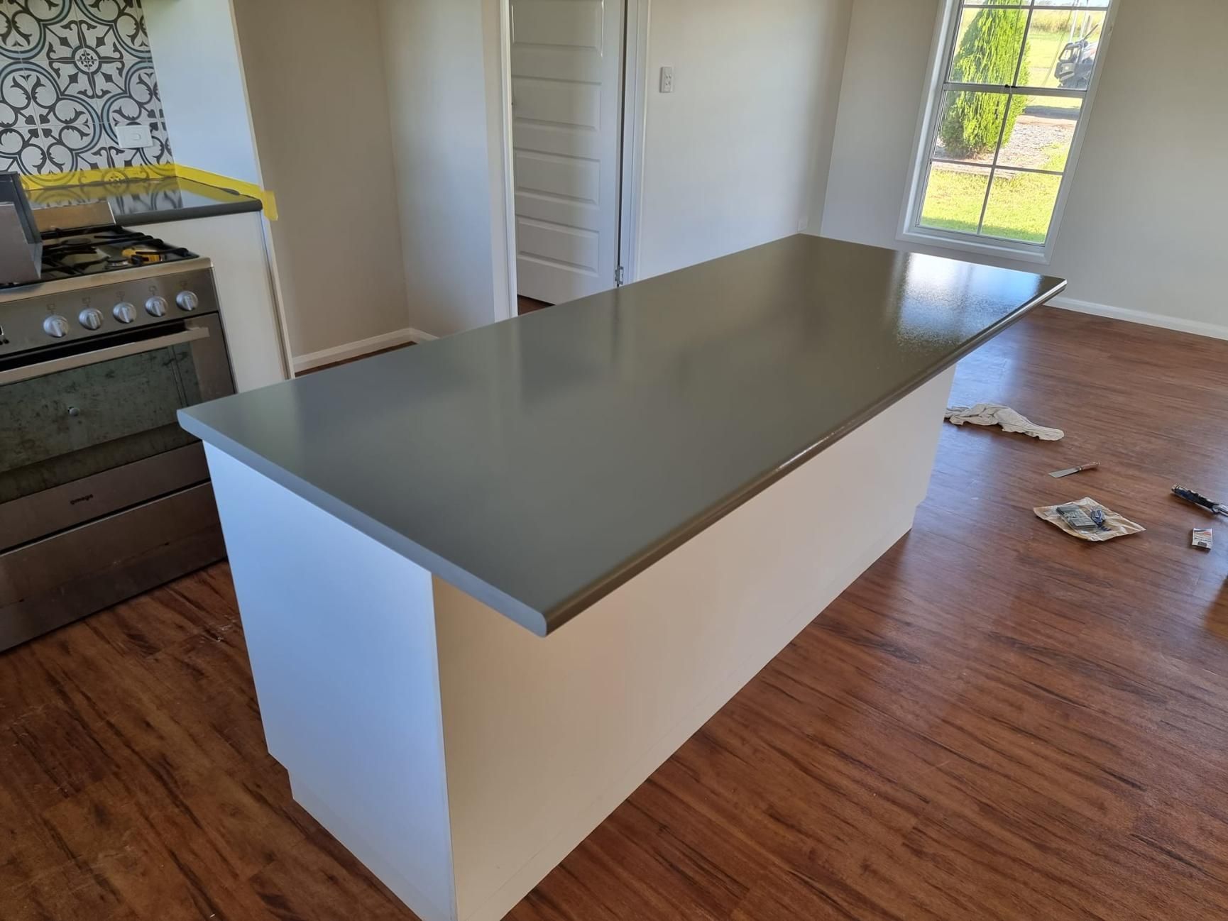 A Kitchen With A Large Island In The Middle Of The Room — LMS Painting & Maintenance Pty Ltd In Thornton, NSW