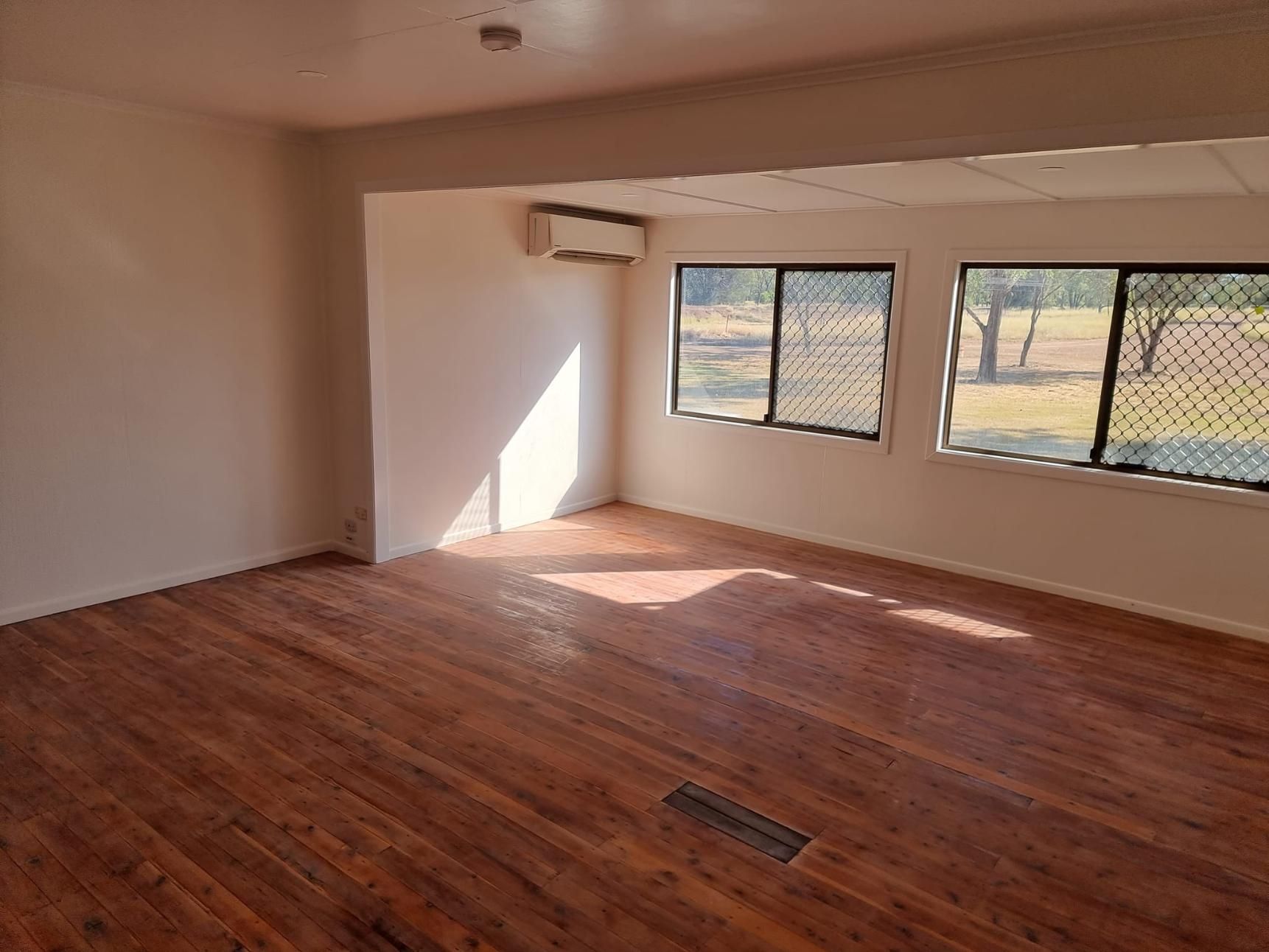 An Empty Room With Hardwood Floors And A Lot Of Windows — LMS Painting & Maintenance Pty Ltd In Singleton, NSW