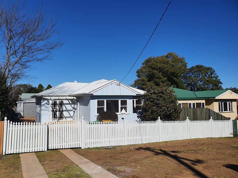 A House With A White Picket Fence In Front Of It — LMS Painting & Maintenance Pty Ltd In Singleton, NSW