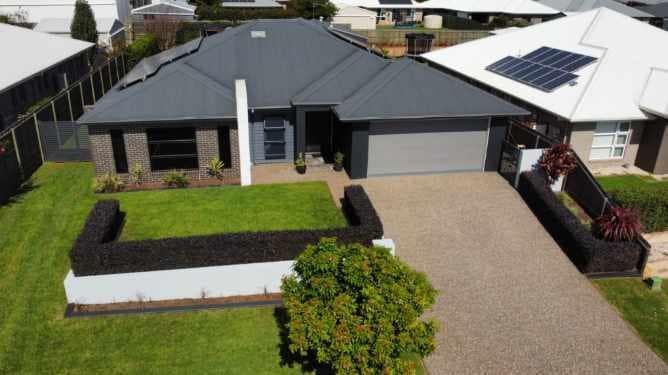 An Aerial View Of A House With A Lush Green Lawn And A Driveway — LMS Painting & Maintenance Pty Ltd In Singleton, NSW