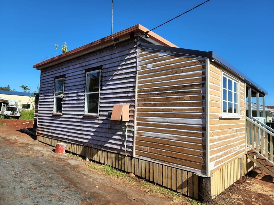 A Small House With A Purple Siding And A Wooden Porch — LMS Painting & Maintenance Pty Ltd In North Lambton, NSW