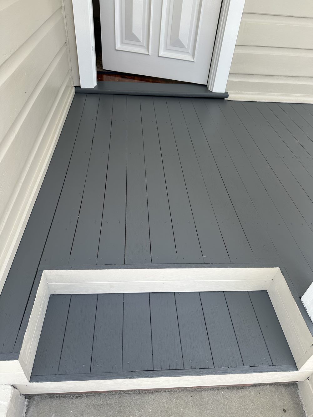 A gray porch with a white door and steps — LMS Painting & Maintenance Pty Ltd In North Lambton, NSW