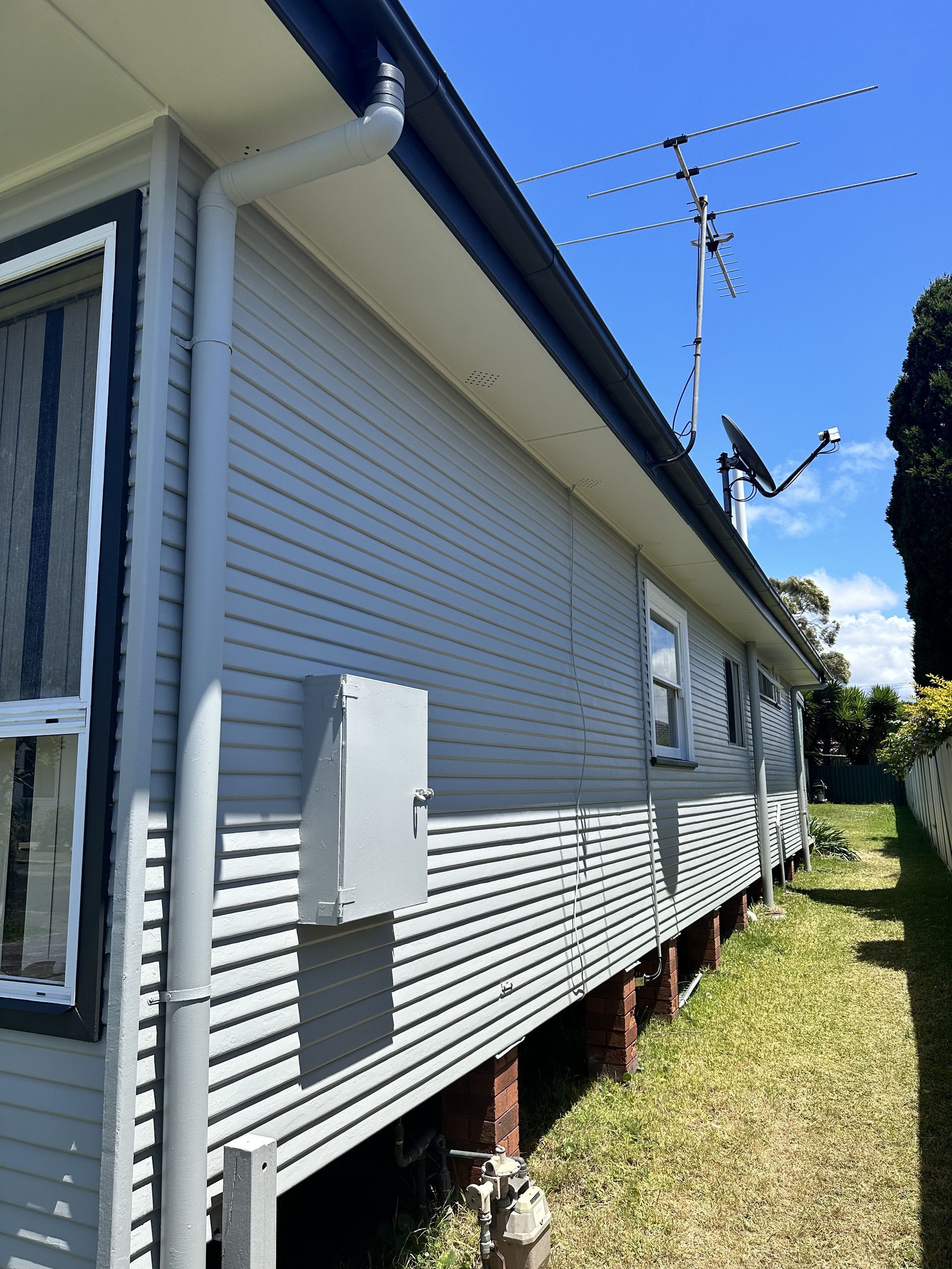 A white house with a satellite dish on the roof — LMS Painting & Maintenance Pty Ltd In North Lambton, NSW