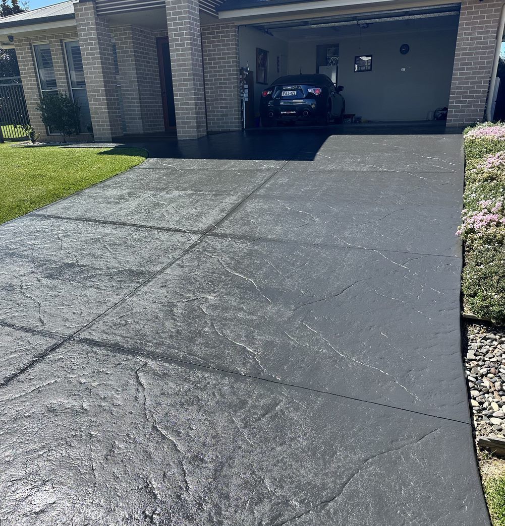 A car is parked in a driveway in front of a house  — LMS Painting & Maintenance Pty Ltd In North Lambton, NSW