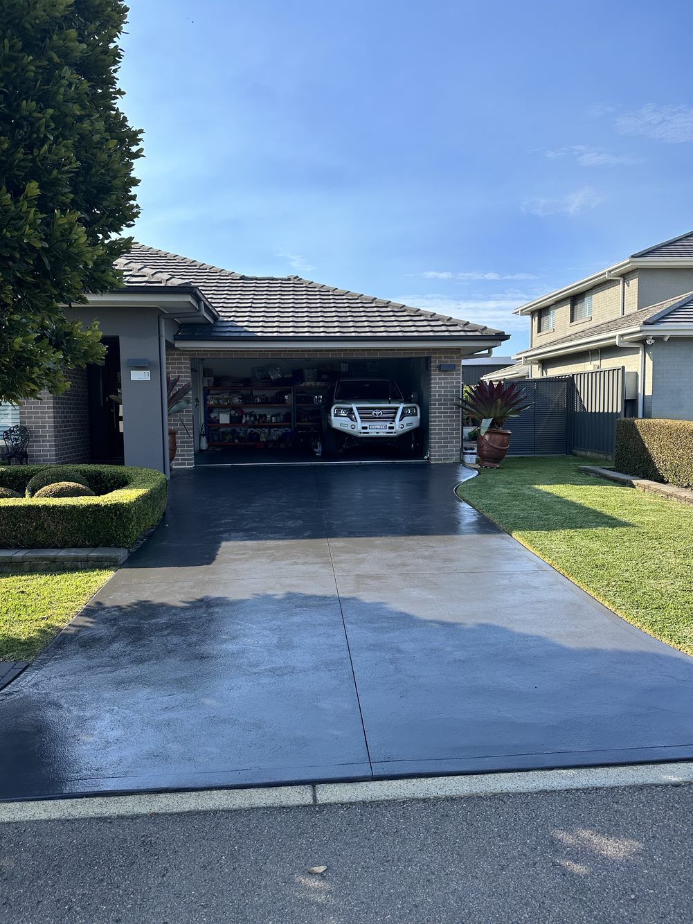 A car is in a garage in front of a house  — LMS Painting & Maintenance Pty Ltd In North Lambton, NSW
