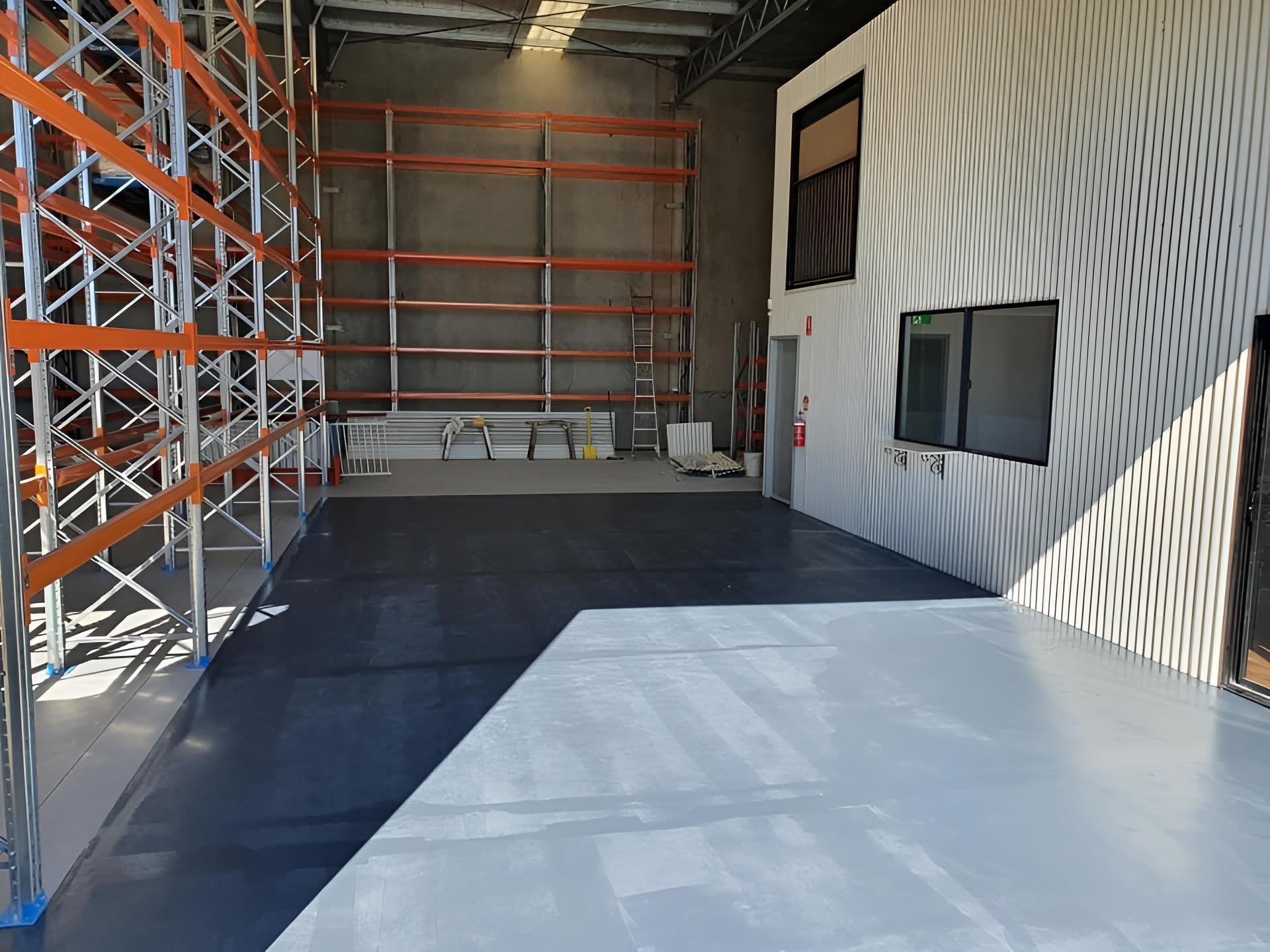 A Large Warehouse With Lots Of Shelves And A Concrete Floor — LMS Painting & Maintenance Pty Ltd In Swansea, NSW