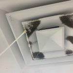 mold inspection services houston White air vent with dark debris being cleaned with a swab.