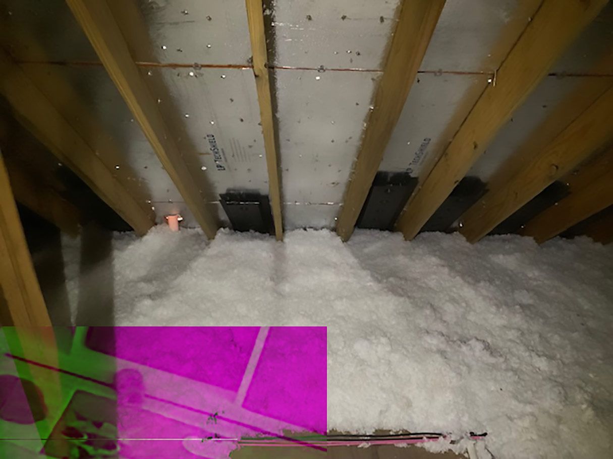 Attic with wood beams, white insulation, and a partly obscured pink and green overlay.