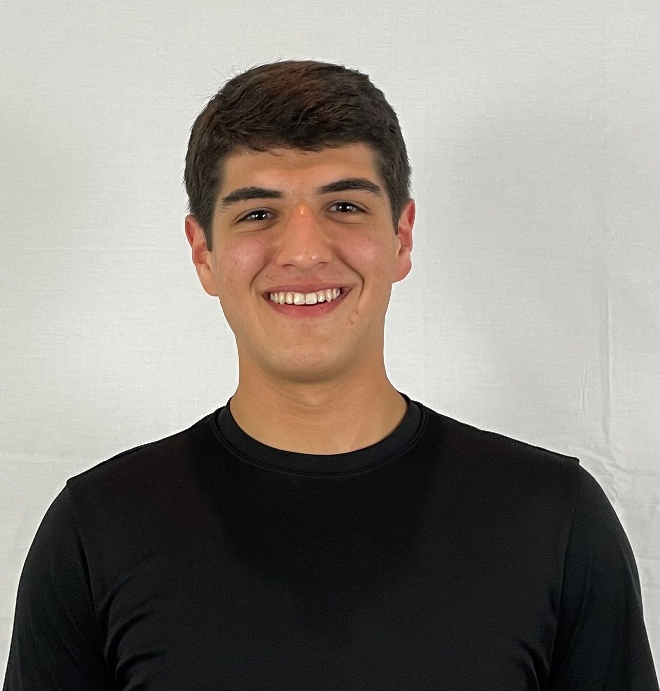 Smiling person in a black shirt against a plain light background