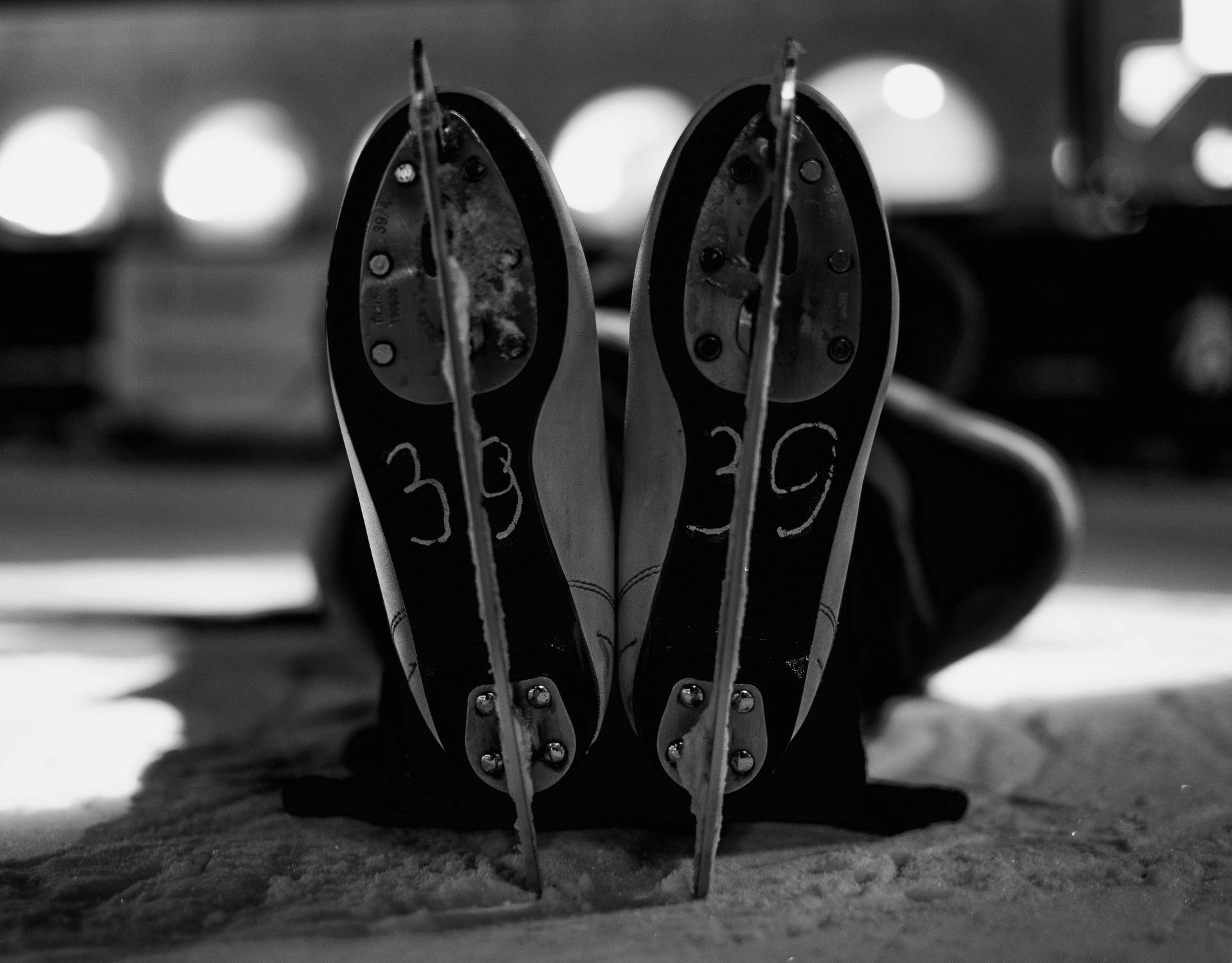 Black-and-white close-up of two metal eye masks or decorative faceplates standing upright on a surface.