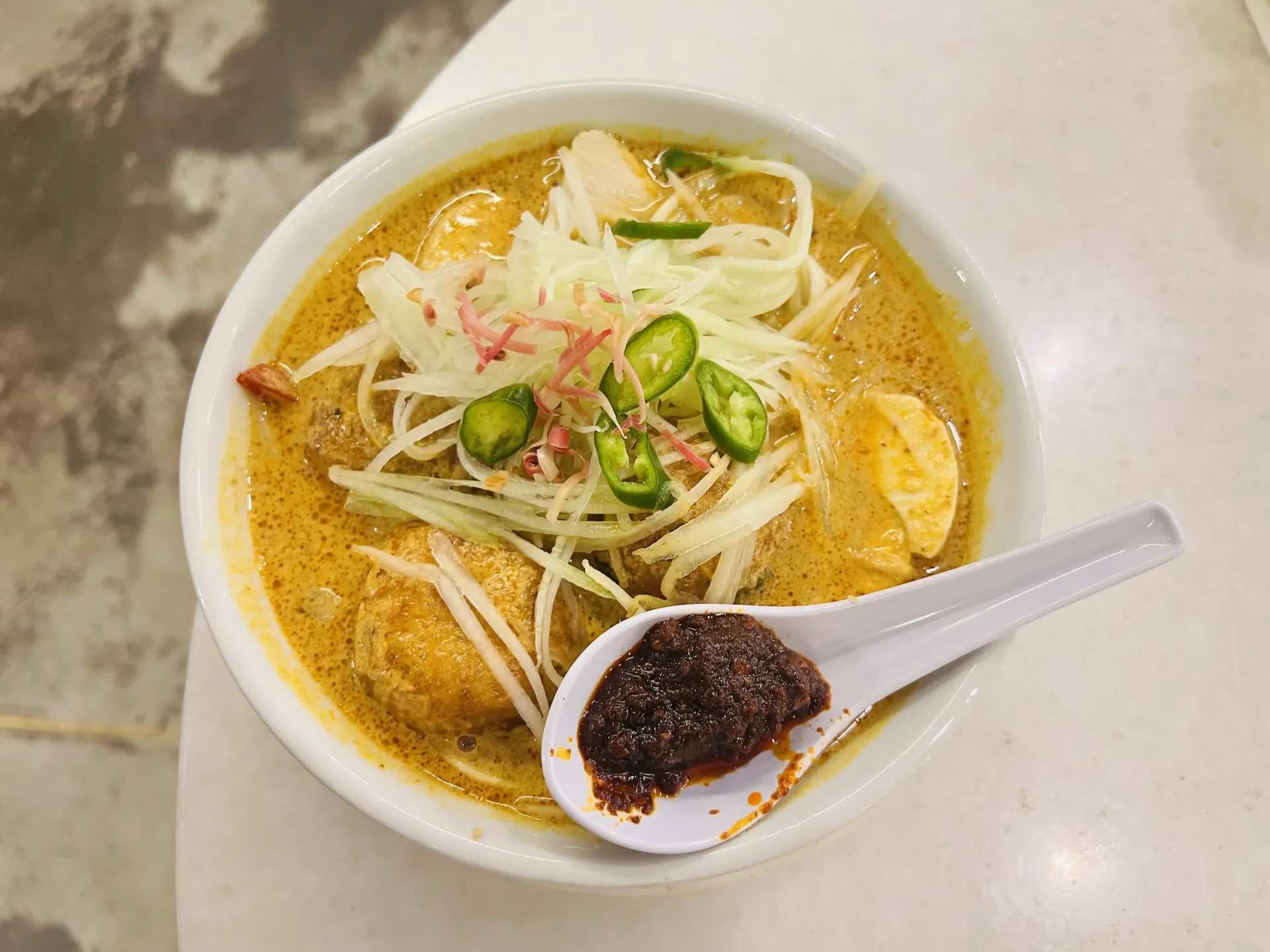 Photo of Nyonya Laksa bowl with egg, noodles and sambal