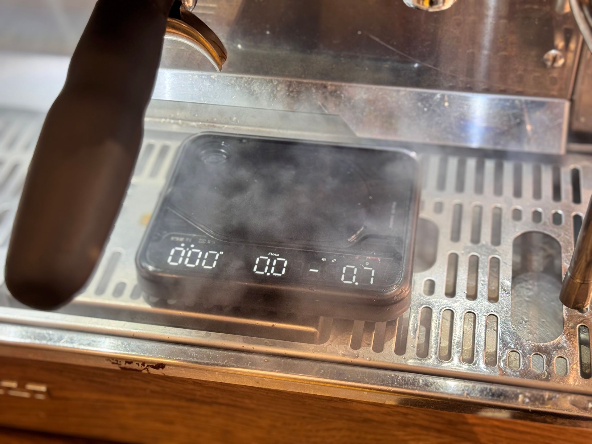 Steam wand and espresso machine drip tray with a digital display showing 00:00.