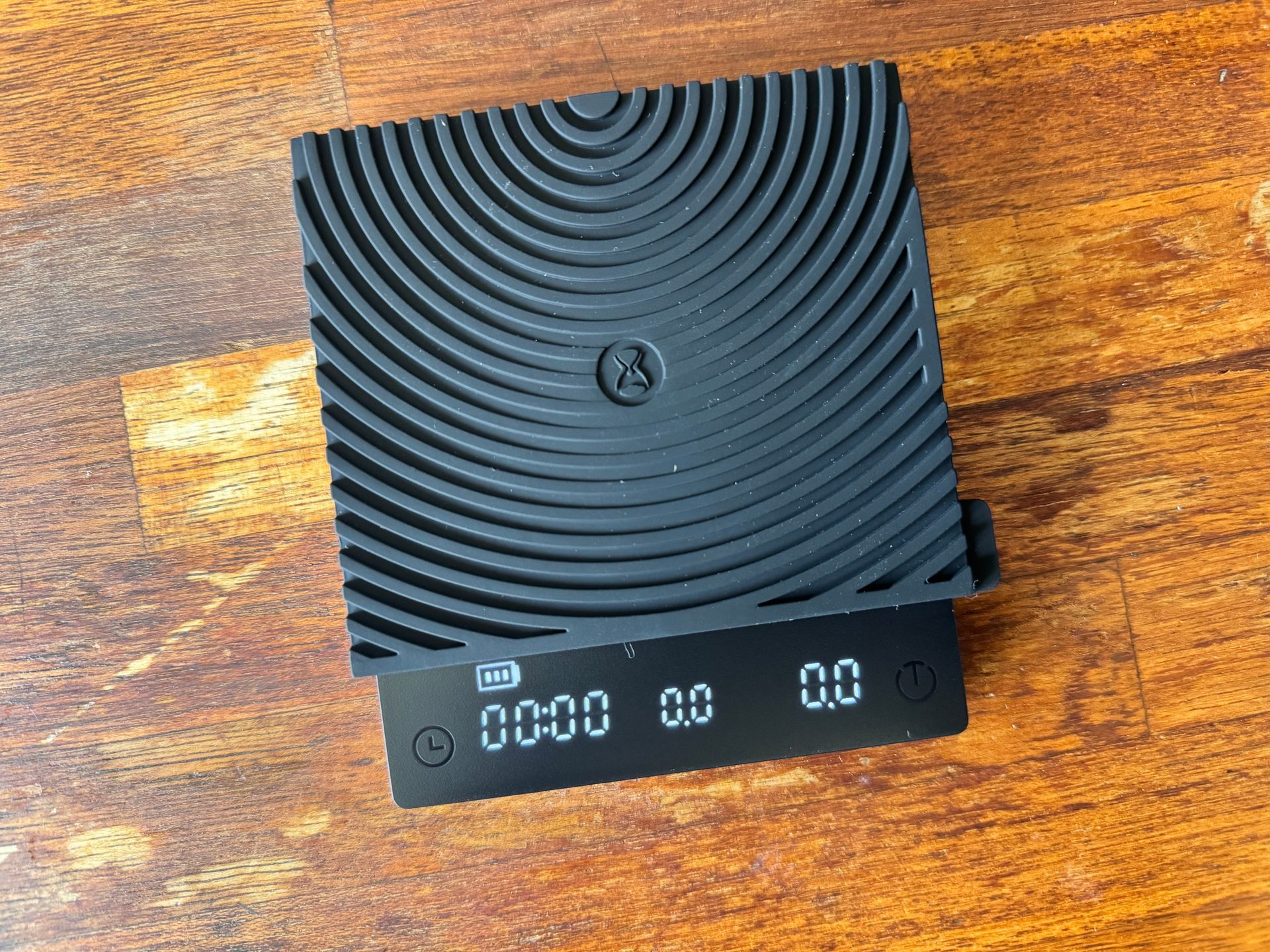 Black coffee scale on a wooden table, displaying 