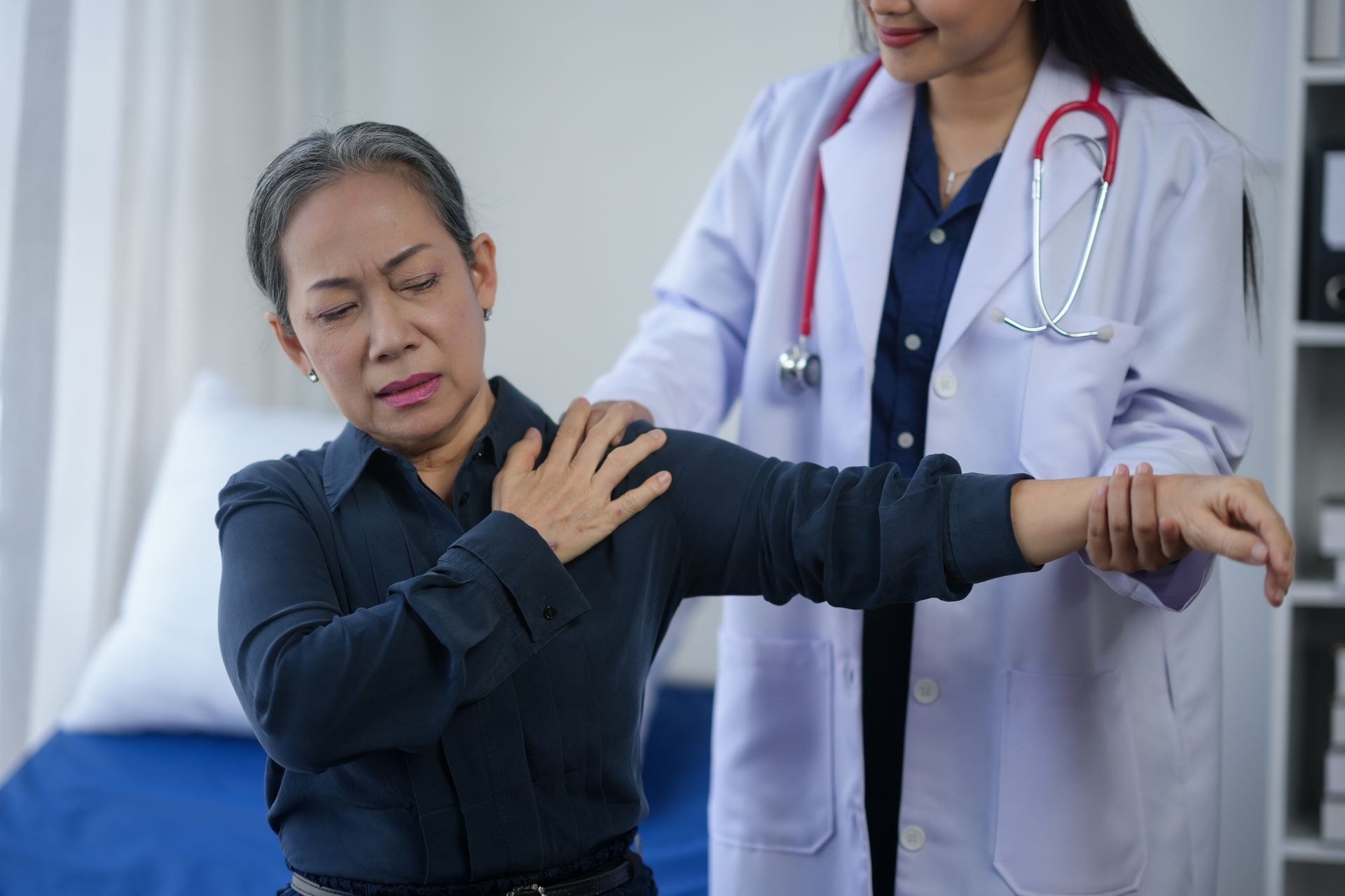 woman experiencing shoulder pain during a medical examination.