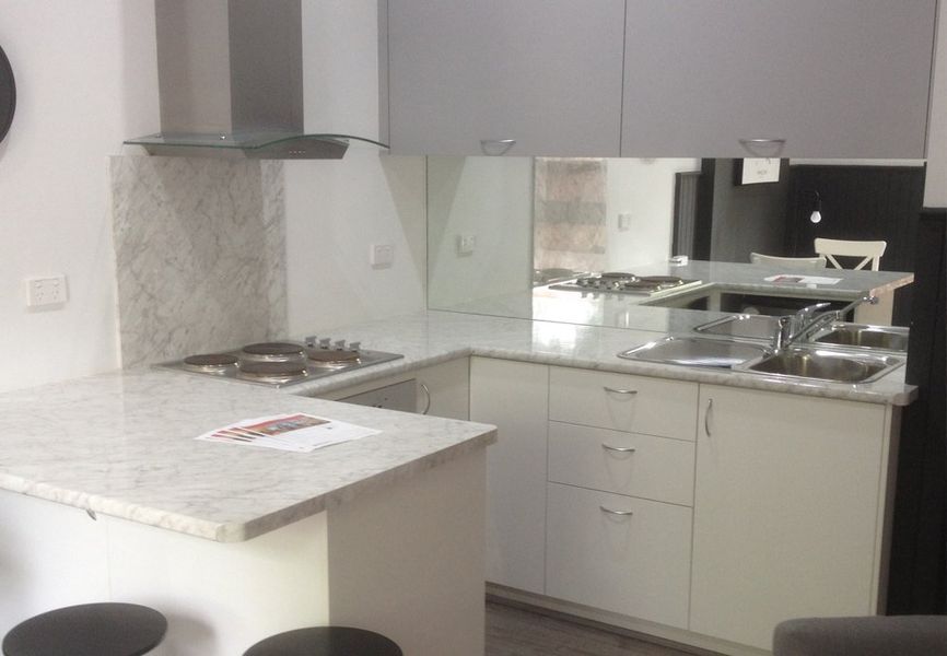 A kitchen with white cabinets and a stove top oven