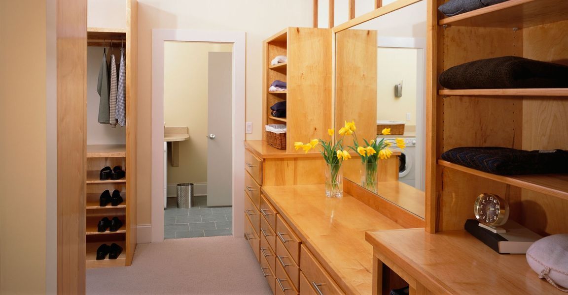 A walk in closet with a vanity and a mirror