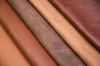 Close-up of overlapping leather swatches in tan, brown, and orange tones