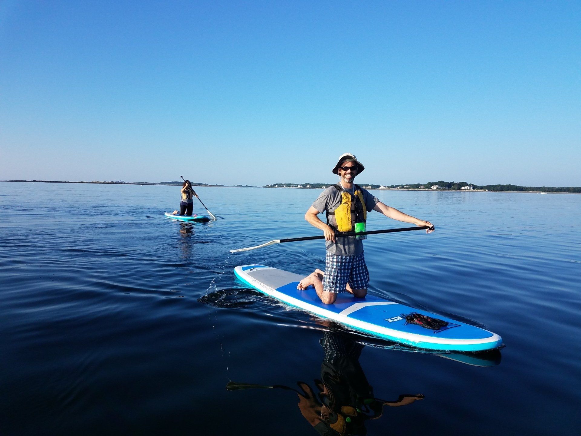 Man and woman on stand up paddle board while on bended knees