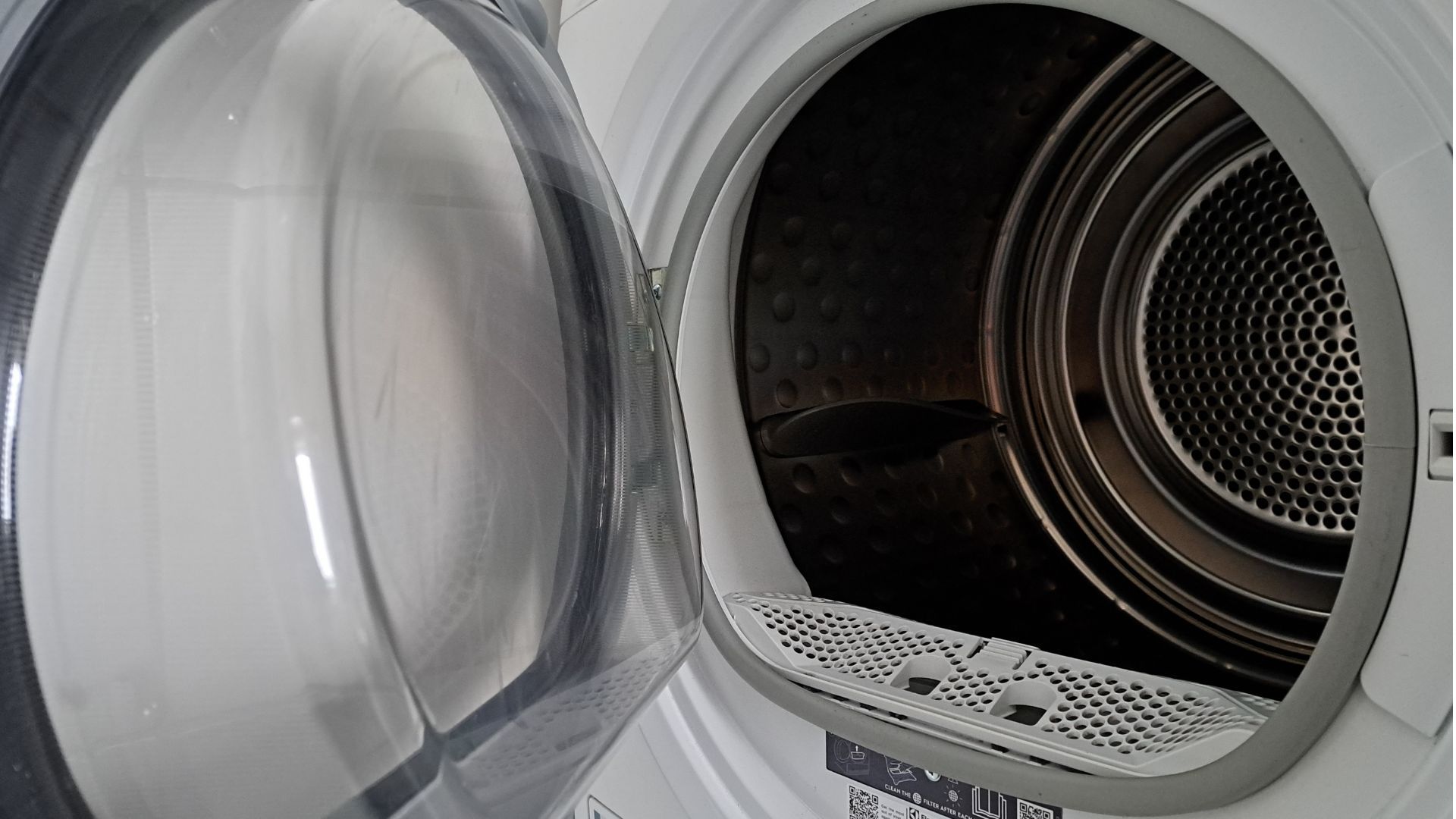 Open front-loading dryer door revealing the drum inside