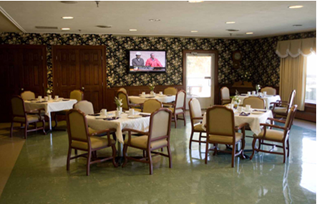 Dining room with multiple tables set for meals, chairs arranged around them.