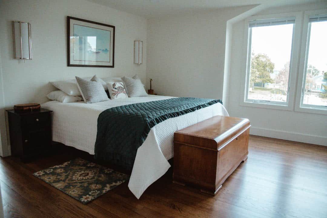 A bedroom with a large bed and a wooden bench.