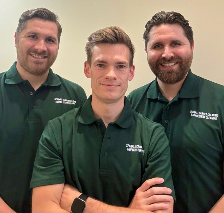 Three men are posing for a picture and one of them is wearing a shirt that says ' fullerton ' on it