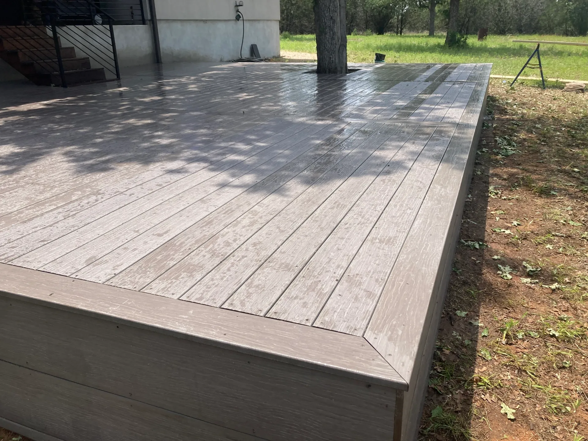Raised deck built around a tree in a residential backyard, Burnet TX