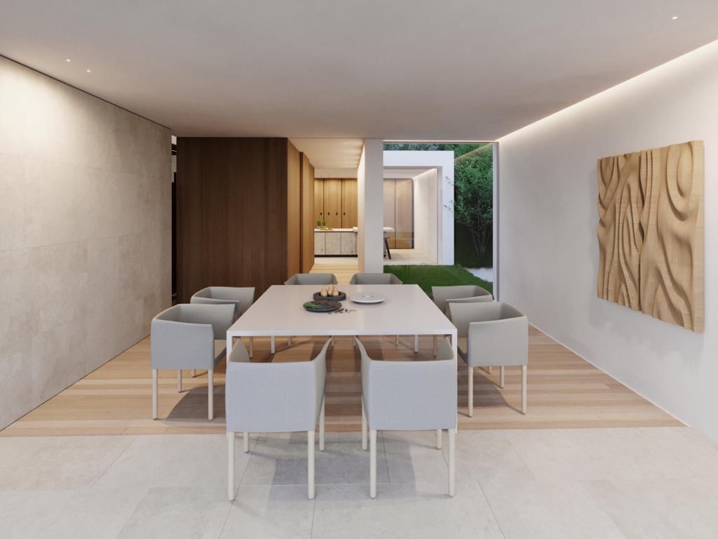 Moderna cucina bianca con isola in marmo, mobili in legno chiaro e lampade a sospensione.