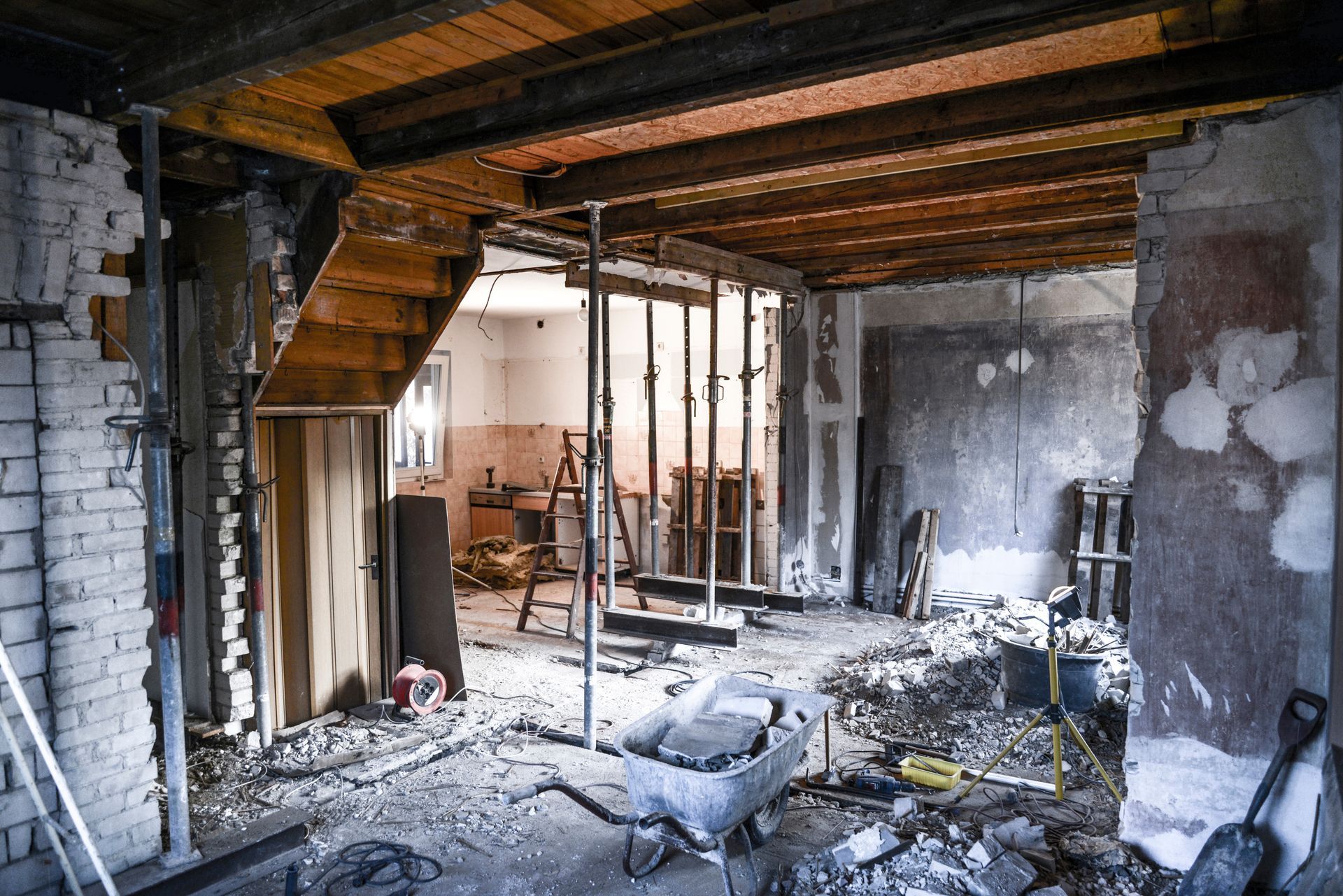 Innenabbruch: freiliegende Balken und Wände, Schutt auf Boden, Treppe und Stützstrukturen.