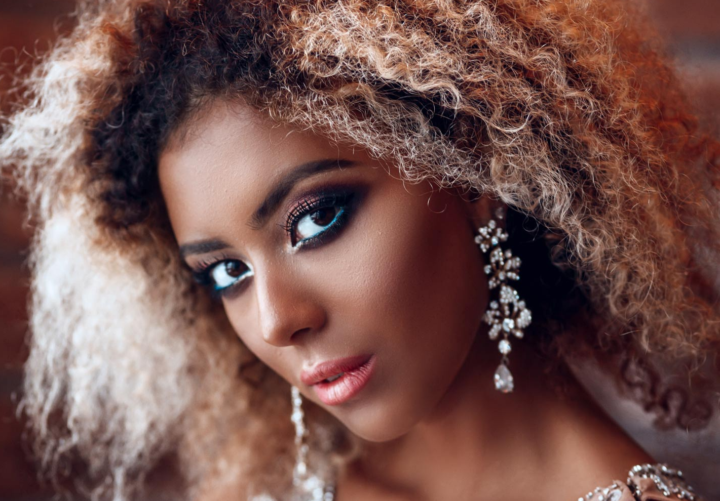 A close up of a woman wearing earrings and makeup.