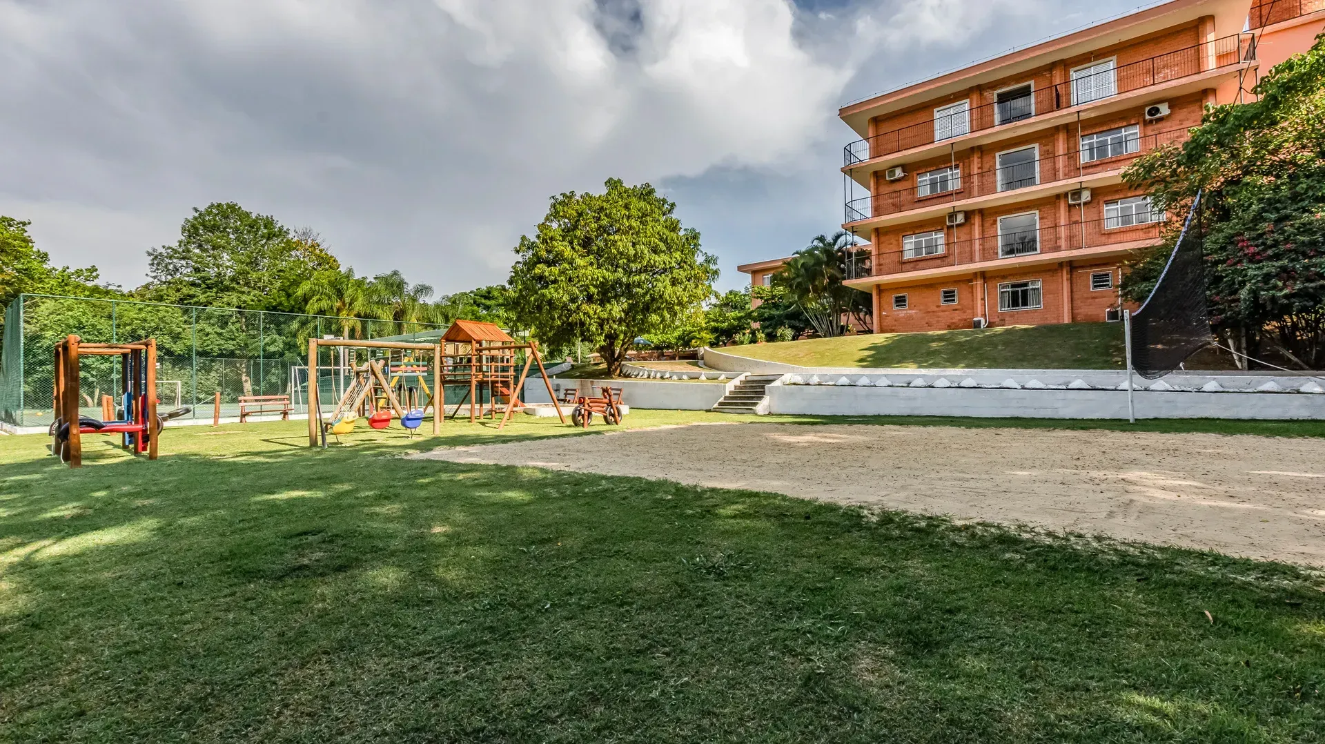 um grande prédio laranja com um playground em frente.